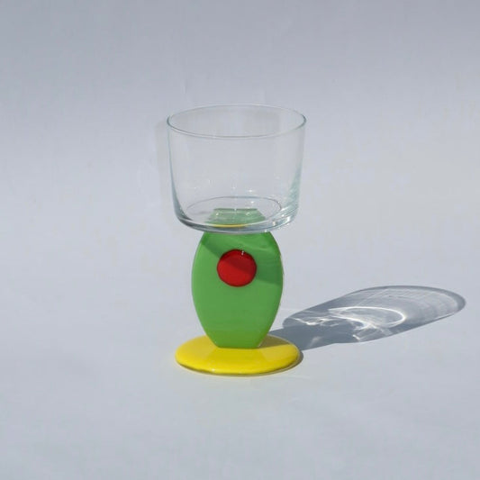 Clear glass with a olive stem on a gray background