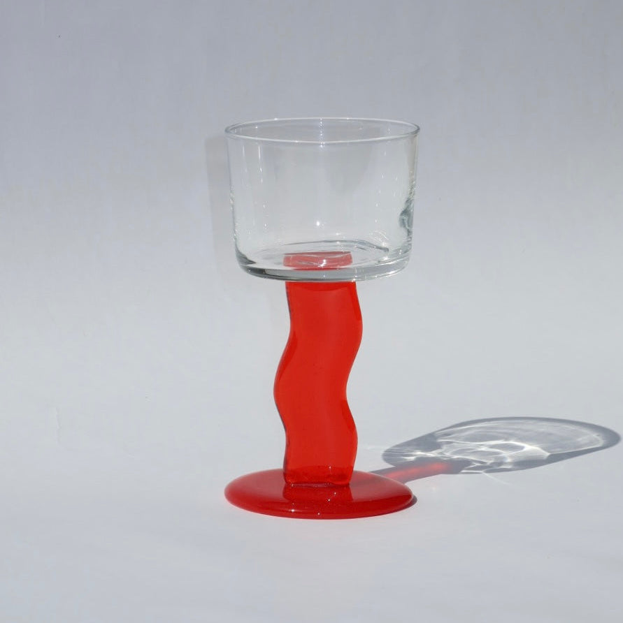 Clear glass with a red base on a gray background