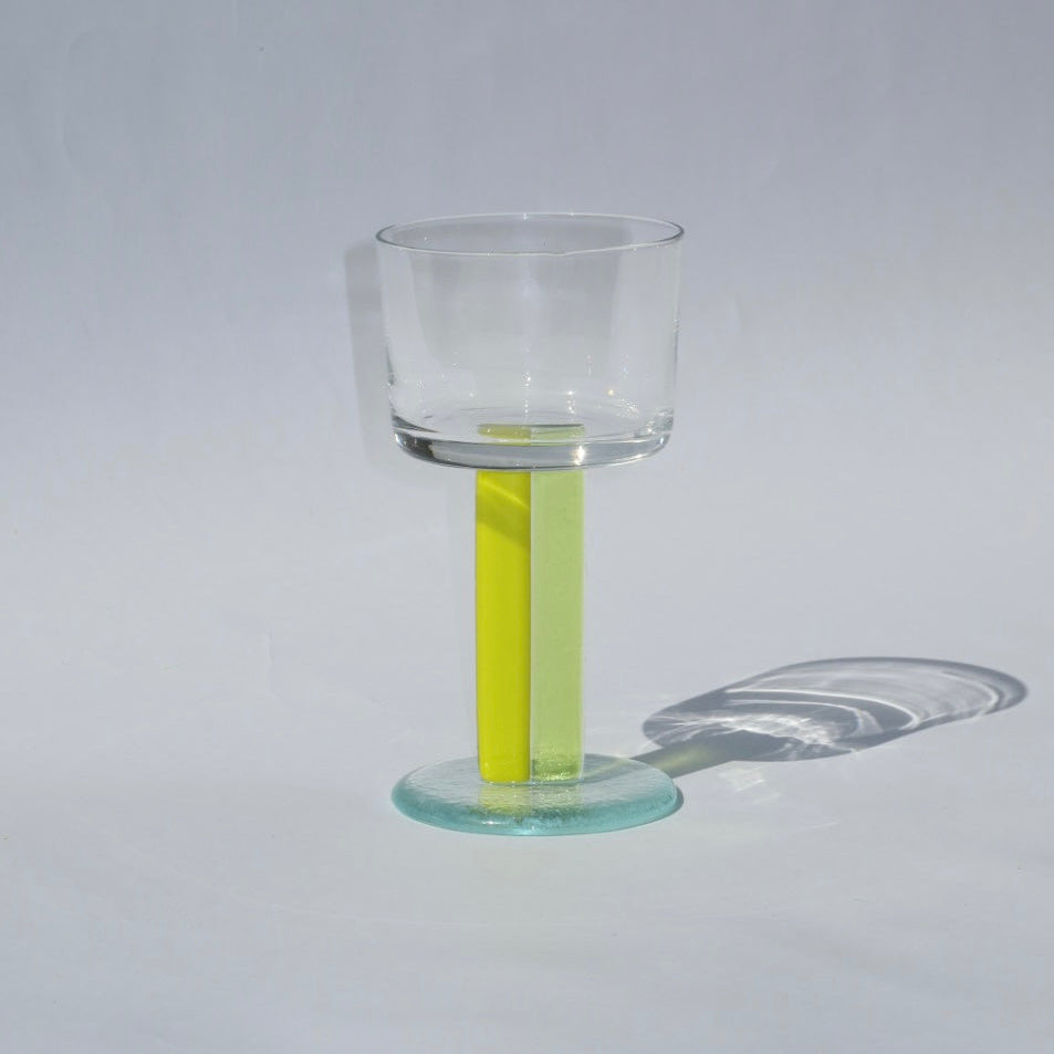 Clear glass with a yellow liquid on a gray background